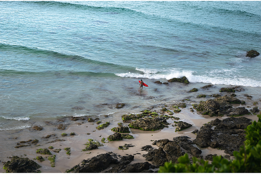 Surfer entering sea